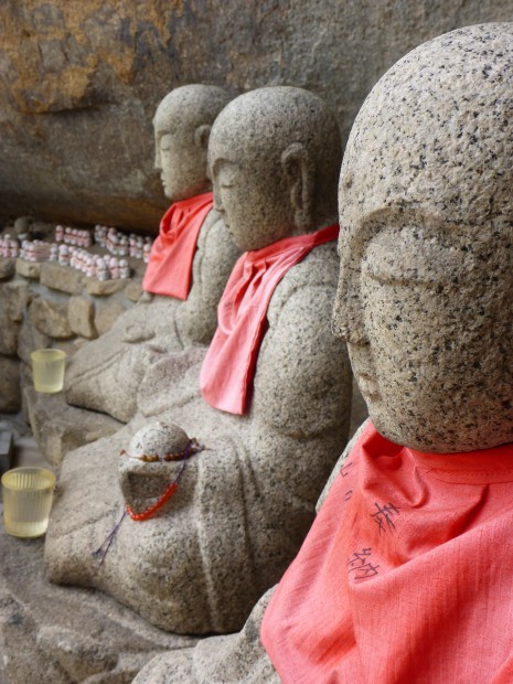 Nahezu alle Buddas sind hier mit Muetzen oder Umhaengen geschmueckt